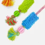Pet enjoying interactive tug toy with plush mop section in home play area