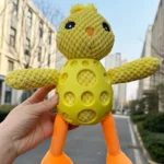 Pet enjoying interactive chicken squeaky toy in garden